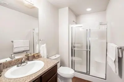 a white bathroom with a shower and a sink at Private 2Bdrm Apartment Convenient to All in Greeley
