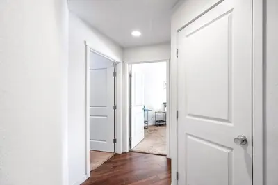 an empty hallway with a white door and a mirror at Private 2Bdrm Apartment Convenient to All in Greeley