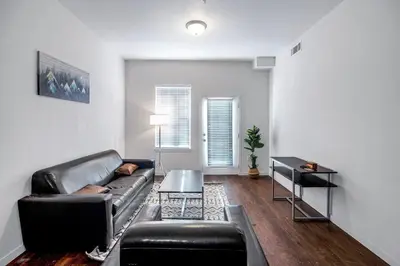 a living room with a leather couch and a table at Private 2Bdrm Apartment Convenient to All in Greeley