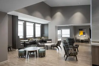 a waiting room with tables and chairs and windows at Residence Inn by Marriott Denver Aurora in Aurora