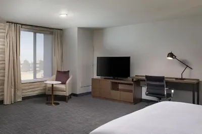 a hotel room with a television and a desk and chair at Residence Inn by Marriott Denver Aurora in Aurora