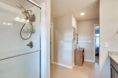 a bathroom with a shower with a glass door at Fire Pit and Shuffleboard Suburban Denver Home in Denver