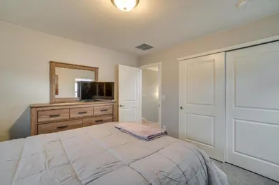 a bedroom with a bed and a tv and a mirror at Fire Pit and Shuffleboard Suburban Denver Home in Denver