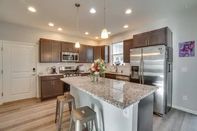 a kitchen with a granite counter top and stainless steel appliances at Fire Pit and Shuffleboard Suburban Denver Home in Denver