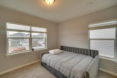 a bedroom with a bed and two windows at Fire Pit and Shuffleboard Suburban Denver Home in Denver