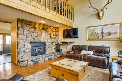 a living room with a couch and a stone fireplace at Private Deck and Hot Tub Silverthorne Home! in Silverthorne
