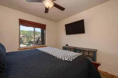 a bedroom with a bed with a ceiling fan and a window at Trailhead Lodges 821 in Winter Park