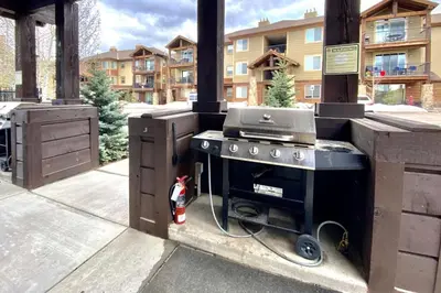 a outdoor kitchen with a grill on a patio at Trailhead Lodges 821 in Winter Park