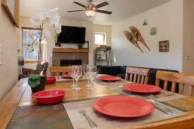 a dining room table with red plates and wine glasses at Trailhead Lodges 821 in Winter Park