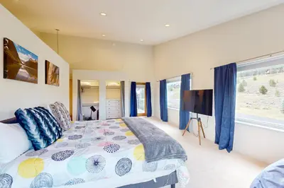 a bedroom with a bed and a flat screen tv at Sakura House in Tabernash