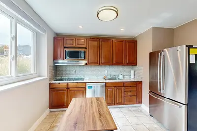 a kitchen with wooden cabinets and a wooden table at Sakura House in Tabernash