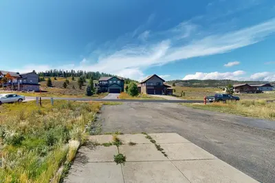 an empty road in a field with houses in the background at Sakura House in Tabernash