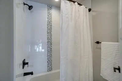 a bathroom with a shower with a white shower curtain at Family-Friendly Townhome about 2 Mi to Windsor Lake! in Windsor