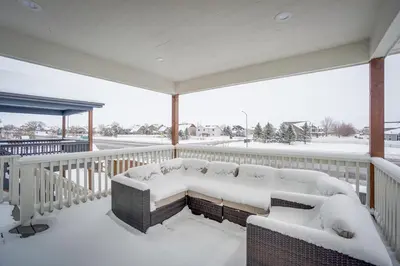 a porch with a couch covered in snow at Family-Friendly Townhome about 2 Mi to Windsor Lake! in Windsor