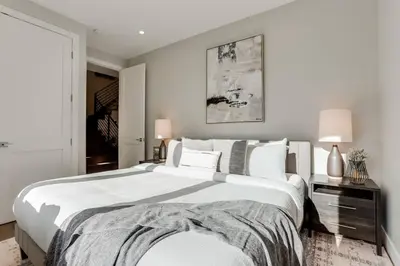 a bedroom with a large bed with white sheets and pillows at Zen Haus* Lavish Getaway w/ Gym, Sauna, Hot Tub in Denver