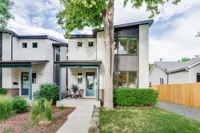 a white house with a tree and a fence at Zen Haus* Lavish Getaway w/ Gym, Sauna, Hot Tub in Denver