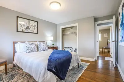 a bedroom with a bed with a blue comforter at Large Gorgeous House * Patio w/ Outdoor Dining in Denver