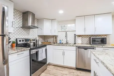a kitchen with white cabinets and stainless steel appliances at Large Gorgeous House * Patio w/ Outdoor Dining in Denver