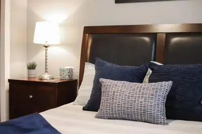 a bed with blue and white pillows and a lamp at NEW Modern Home w/ Beautiful Finishes! in Denver