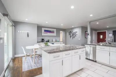 a kitchen with white cabinets and a white table at NEW Modern Home w/ Beautiful Finishes! in Denver