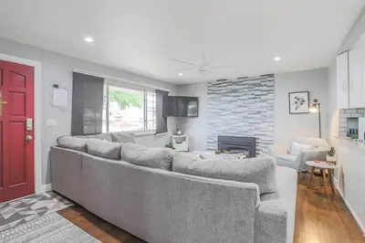 a living room with a large couch and a red door at NEW Modern Home w/ Beautiful Finishes! in Denver