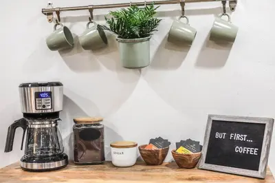 a counter with a coffee maker and cups and a sign at NEW! Gorgeous Colorado Getaway * Glamping Vibes * in Denver