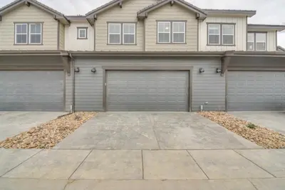 a house with two garage doors in a driveway at Cozy Colorado Home with Putting Green Near Loveland! in Loveland