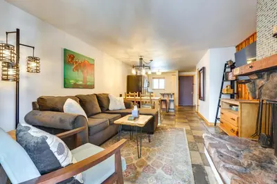 a living room with a couch and a table at Winter Park Condo Rental about 2 Mi to Ski Resort! in Winter Park