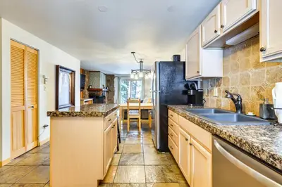 a kitchen with a sink and a refrigerator at Winter Park Condo Rental about 2 Mi to Ski Resort! in Winter Park
