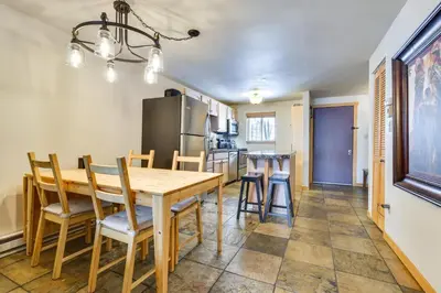 a kitchen and dining room with a wooden table and chairs at Winter Park Condo Rental about 2 Mi to Ski Resort! in Winter Park