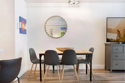 a dining room with a table and chairs and a mirror at Liftside 104 - Keystone in Keystone