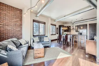 a living room with a couch and a brick wall at 2Bed 2Ba Loft in LoDo RiNo- Mountain BallparkViews in Denver