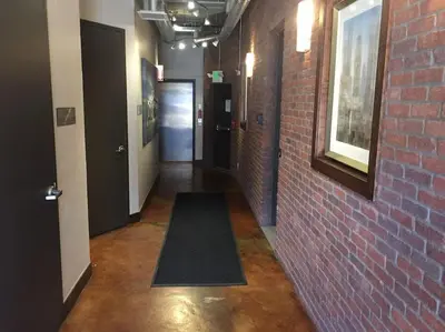 a hallway with a brick wall and a hallway with a rug at 2Bed 2Ba Loft in LoDo RiNo- Mountain BallparkViews in Denver
