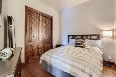 a bedroom with a bed and a wooden door at 2Bed 2Ba Loft in LoDo RiNo- Mountain BallparkViews in Denver