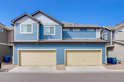 a blue house with two garage doors at Near Hiking, Golfing and Fishing Colorado Retreat! in Henderson