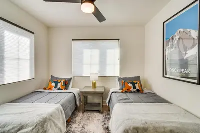 a bedroom with two beds and a table with a lamp at Modern Erie Home - Walk to Downtown! in Erie