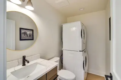 a white bathroom with a sink and a refrigerator at Modern Erie Home - Walk to Downtown! in Erie