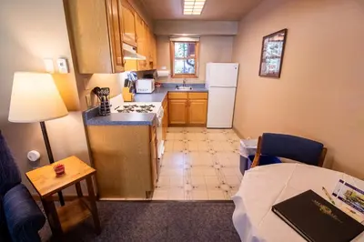 a small kitchen with a refrigerator and a table at Castle Mountain Lodge in Estes Park