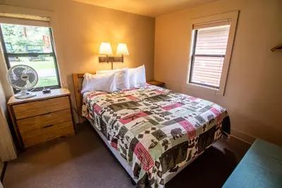 a small bedroom with a bed and a window at Castle Mountain Lodge in Estes Park