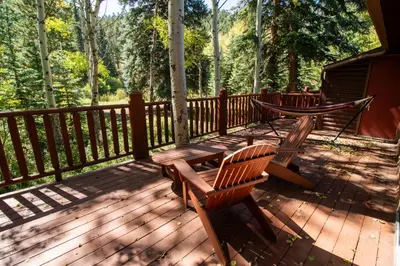 a deck with two benches and a hammock on it at Castle Mountain Lodge in Estes Park