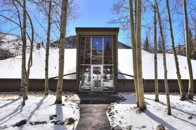 a house with a glass door in the snow at 2056 The Pines condo in Keystone