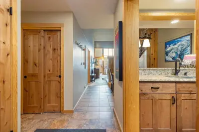 a hallway leading to a kitchen with a sink and a mirror at 2056 The Pines condo in Keystone