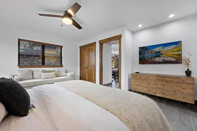 a white bedroom with a large bed and a couch at Luxury Cabin! Fireplace and Jacuzzi! in Estes Park