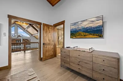 a room with a dresser and a large painting on the wall at Luxury Cabin! Fireplace and Jacuzzi! in Estes Park