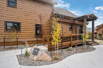 a log cabin with a porch and a fence at Luxury Cabin! Fireplace and Jacuzzi! in Estes Park