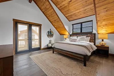 a bedroom with a bed and a wooden ceiling at Luxury Cabin! Fireplace and Jacuzzi! in Estes Park