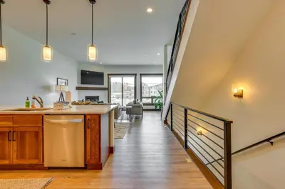 a kitchen with a staircase leading to a living room at Modern Fraser Townhome with Private Hot Tub and Decks! in Fraser