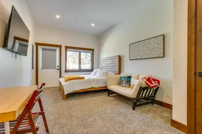 a bedroom with a bed and a chair and a table at Modern Fraser Townhome with Private Hot Tub and Decks! in Fraser