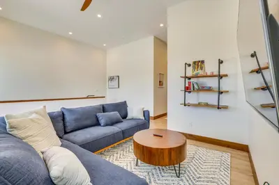 a living room with a blue couch and a wooden table at Modern Fraser Townhome with Private Hot Tub and Decks! in Fraser
