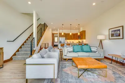 a living room with white furniture and a staircase at Modern Fraser Townhome with Private Hot Tub and Decks! in Fraser